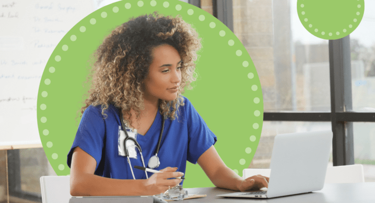 A woman in scrubs looking at her laptop