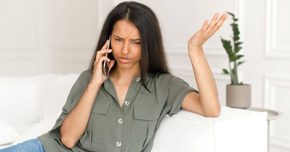 Woman with Hand in the Air in Confusion While on Cellphone Call