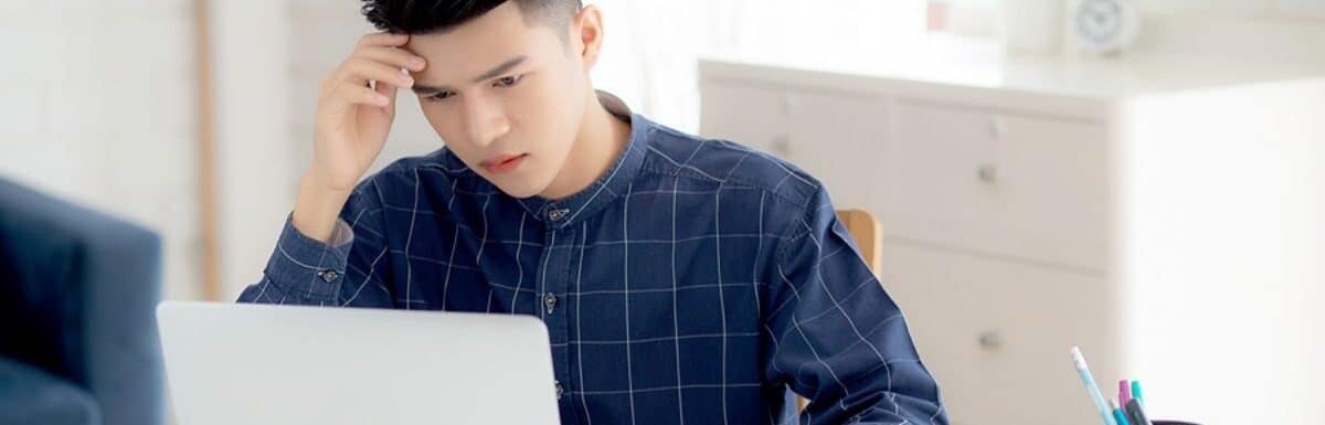 Young asian business man headache during working on laptop computer