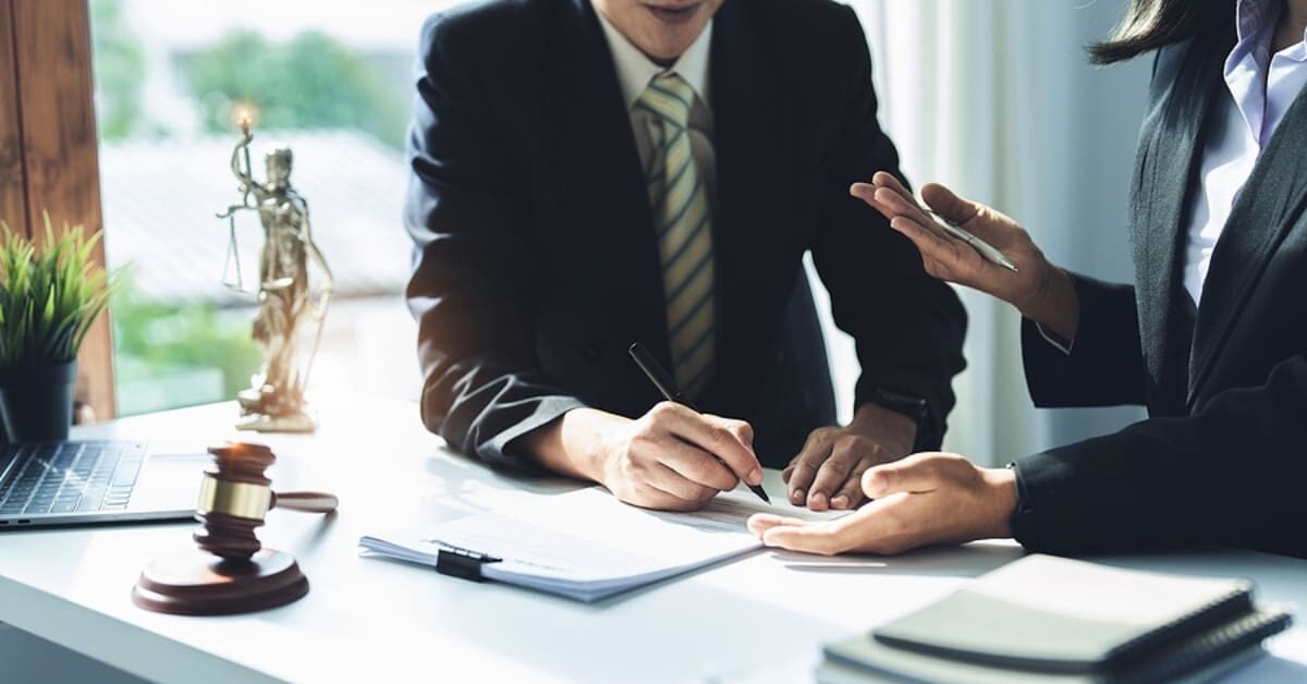 Lawyer holding a pen is consulting with a client to explain the pattern of answering questions before going to court to decide a lawsuit.