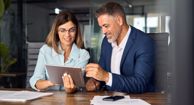 two professionals looking at a tablet discussing AVMA disability insurance