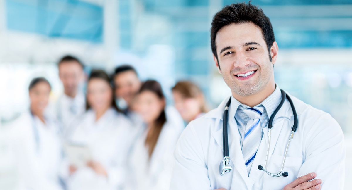 male doctor standing in front of a group of other doctors