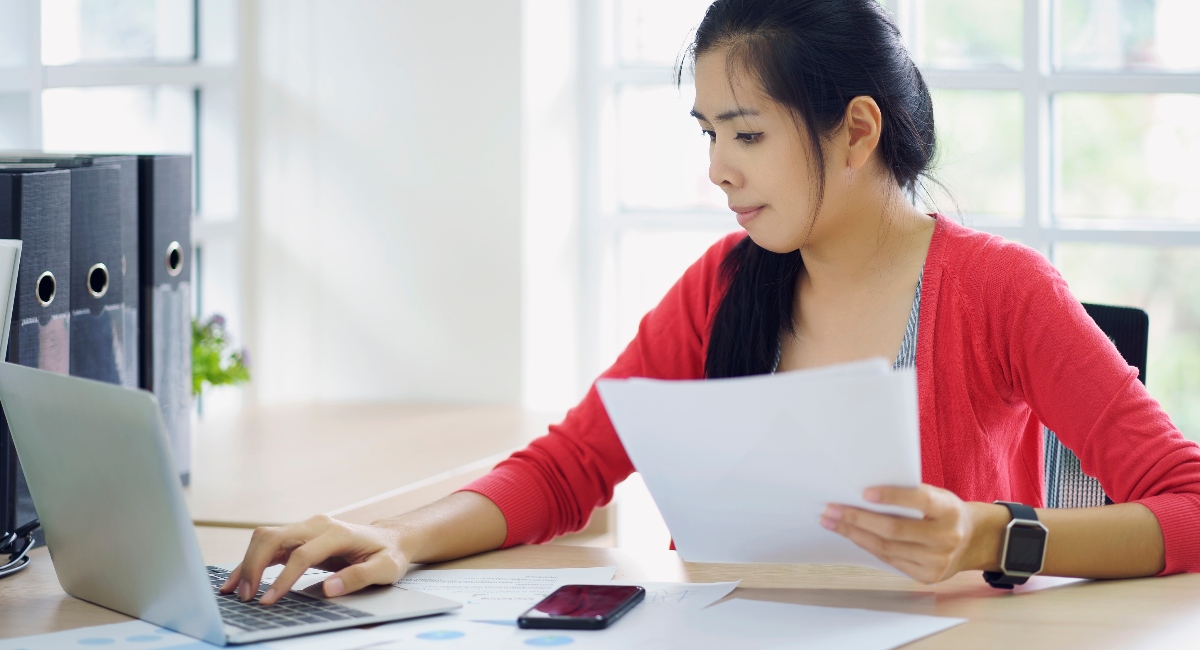 Woman sitting at a desk researching how to submit income-driven repayment recertification