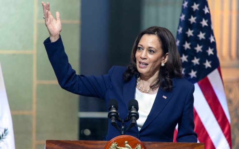 Kamala Harris speaking to a crowd from a podium