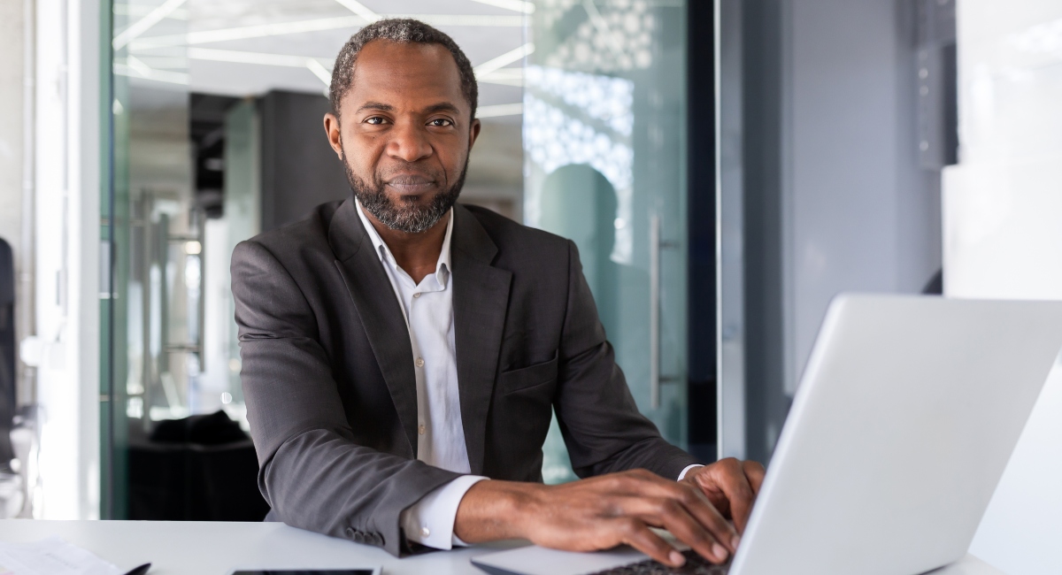 Business man on a laptop looking confused over what repayment plan to pick for Parent PLUS loans.