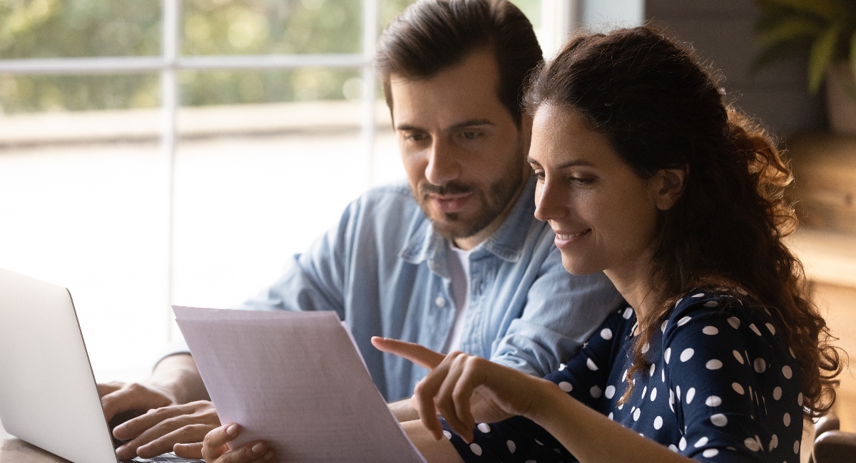 Couple reading documents to compare Guardian vs. Ameritas disability insurance