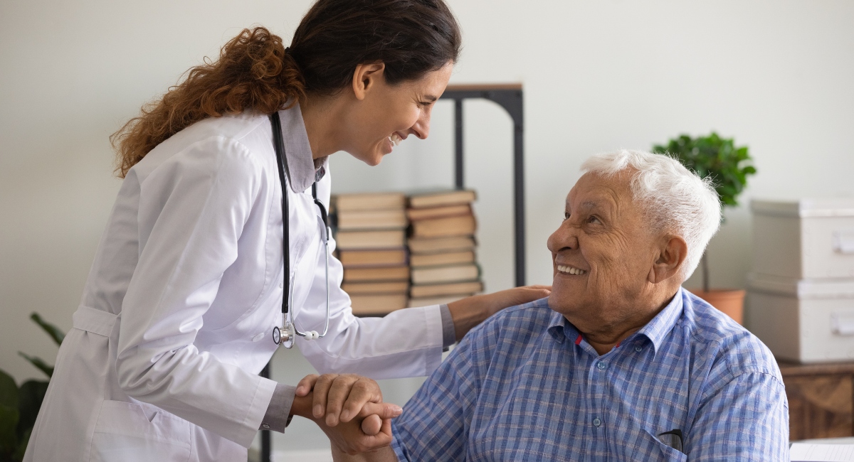 Physician assistant talking to an older man in a wheelchair